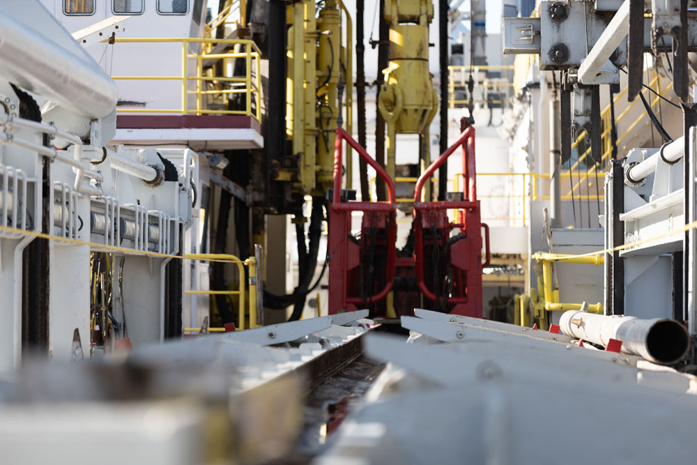 Pipe-racker rails on JOIDES Resolution viewed toward machinery at the rig floor.